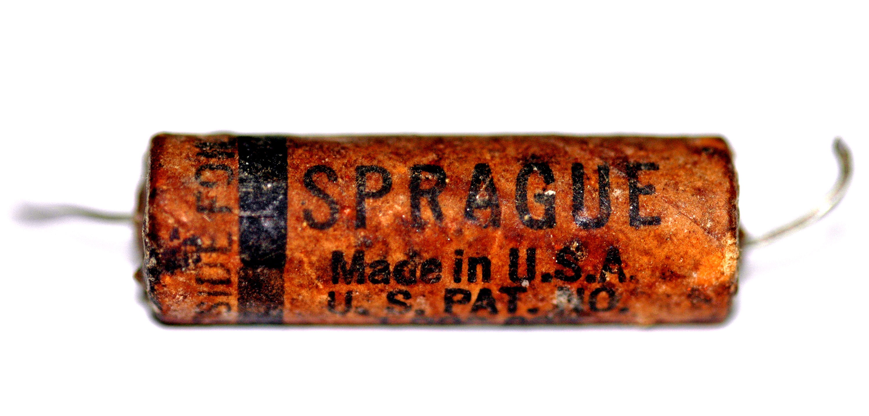 Figure 3 — Wax-paper tubular capacitors in their natural habitat: the underside of a vintage tube-radio chassis, where a handful of them handle coupling, bypassing, and filtering. Every one is a ca…
