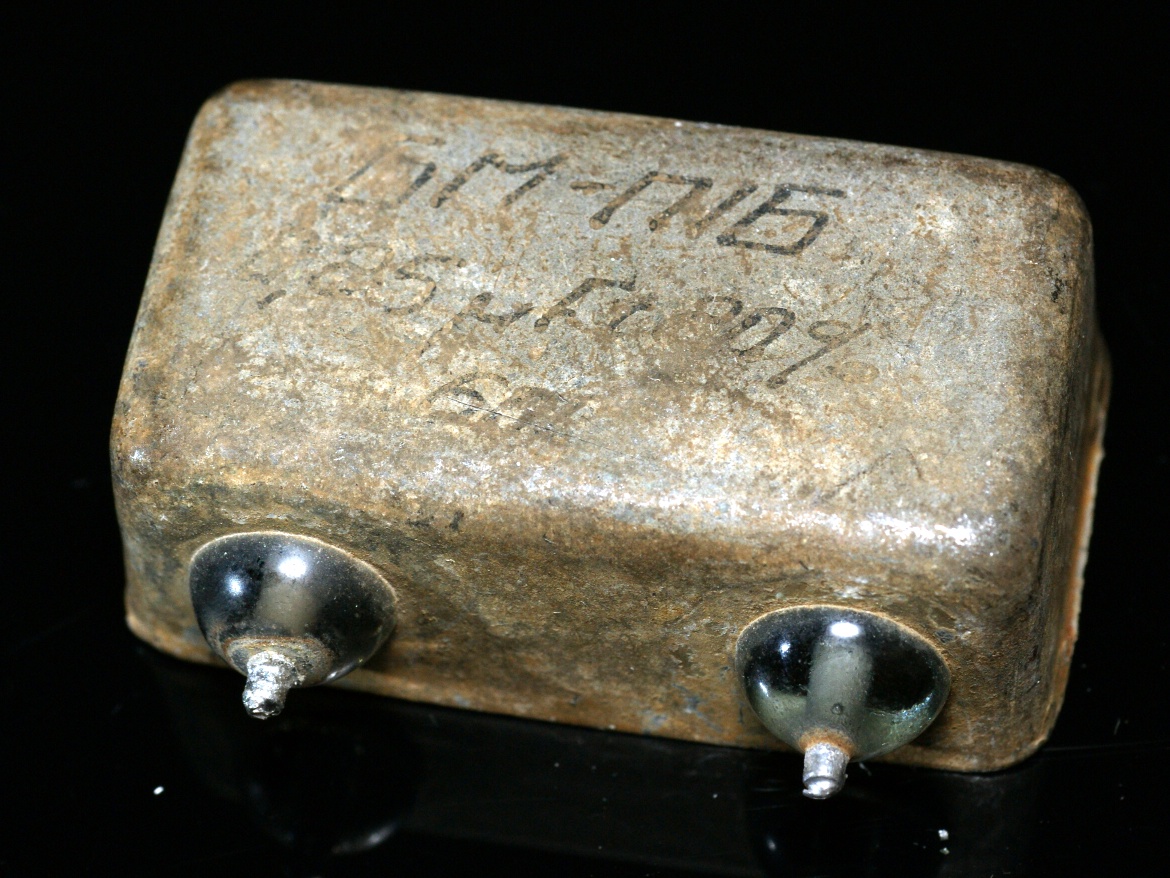 Figure 4 — A hermetically-sealed paper-in-oil (PIO) capacitor in a soldered metal can with glass-bead insulated terminals. Sealed oil-filled types age far better than wax tubulars — but "better" is…