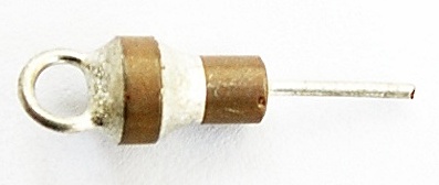Figure 9 — A small ceramic feedthrough capacitor (1 nF). The conductor passes through the middle; the outer electrode bonds to the shield wall, giving a low-inductance coaxial path that shunts high…