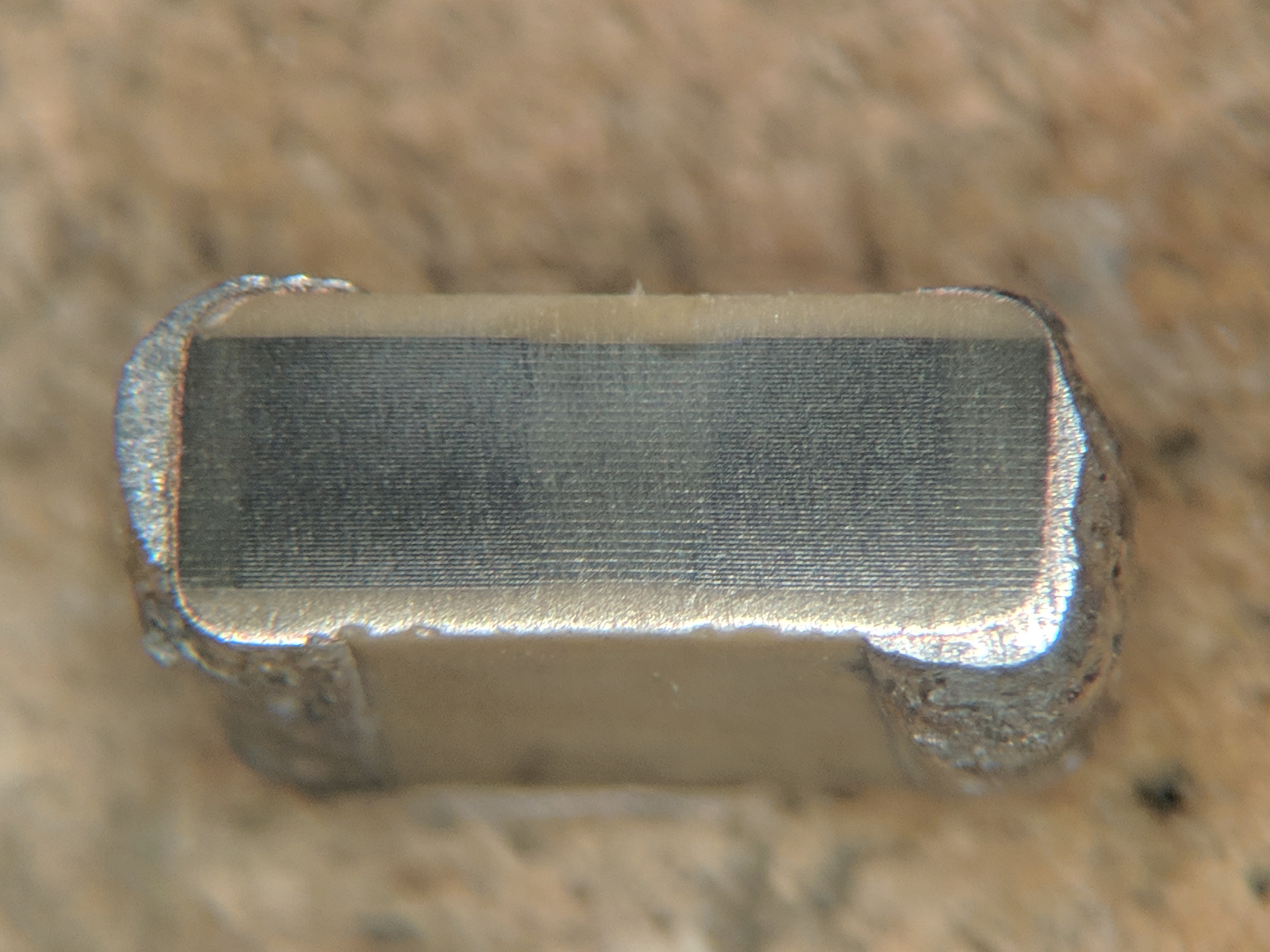 Figure 4 — Microsection through a multilayer ceramic capacitor. The pale horizontal lines are the fired internal electrodes; the darker material between them is the sintered ceramic dielectric. Hun…