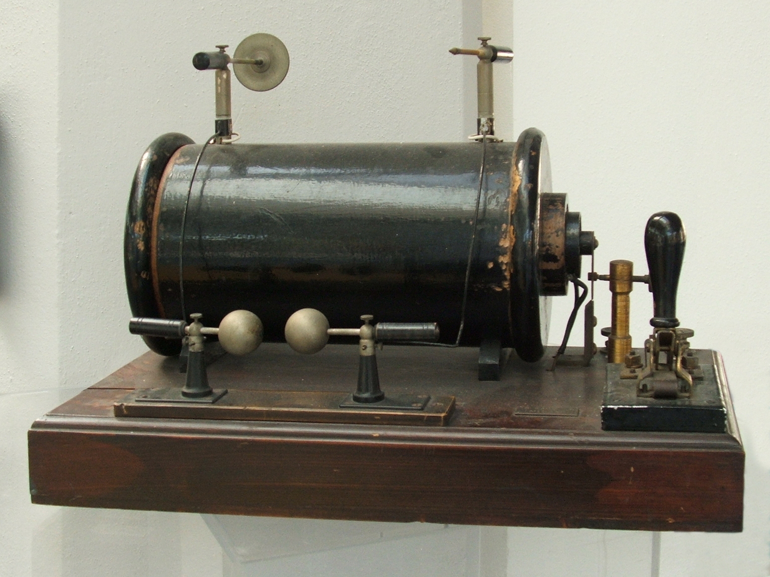 Figure 5 — A Ruhmkorff-type induction coil: a low-voltage primary and a many-turn secondary on a common iron core, with the spring interrupter (right) that chops the primary current and the spark g…