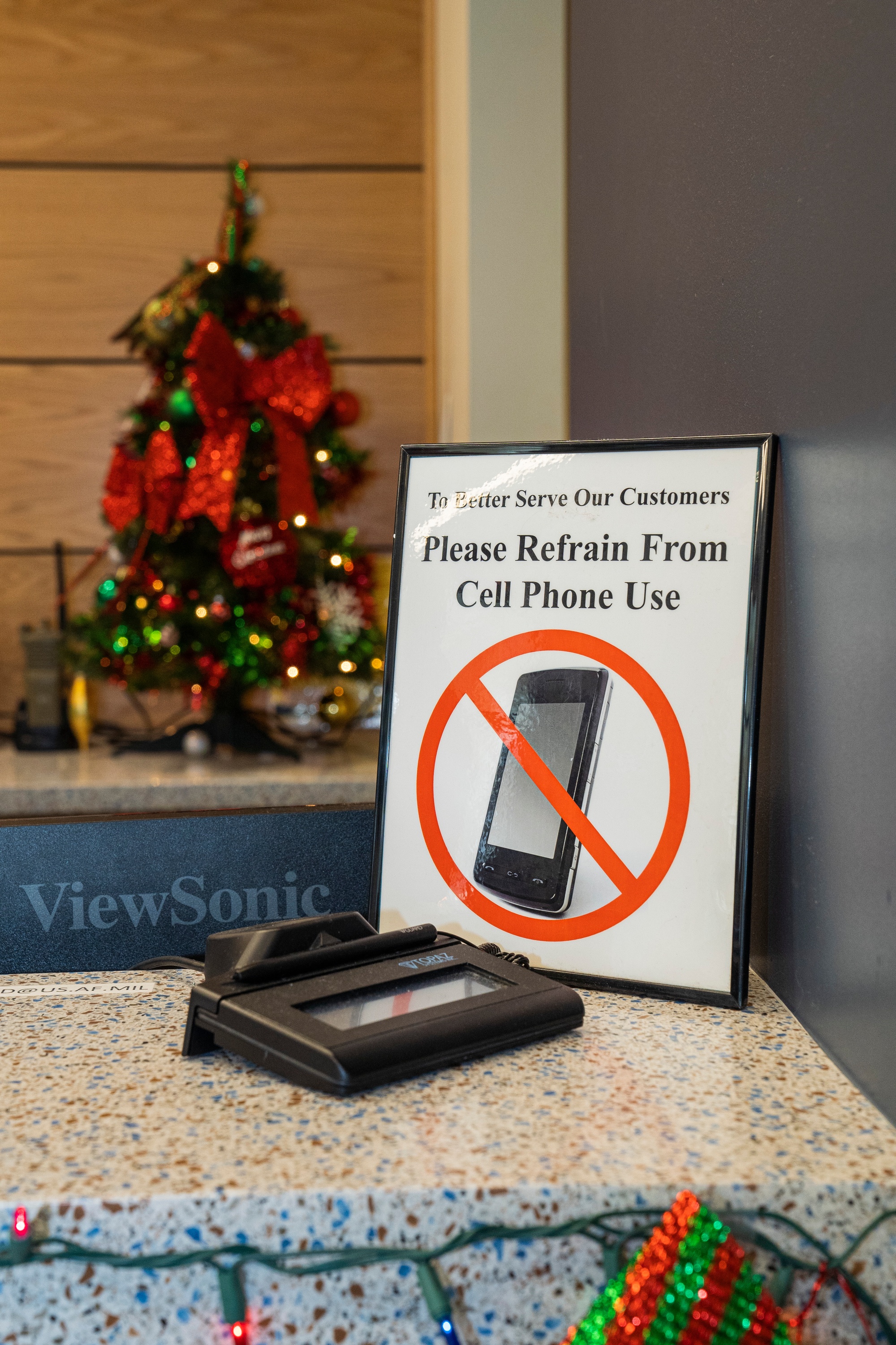 Figure 7 — The most human layer of emanation security: a sign at a controlled entrance directing that cell phones be surrendered or silenced before proceeding. In a SCIF the rule is absolute — a pe…