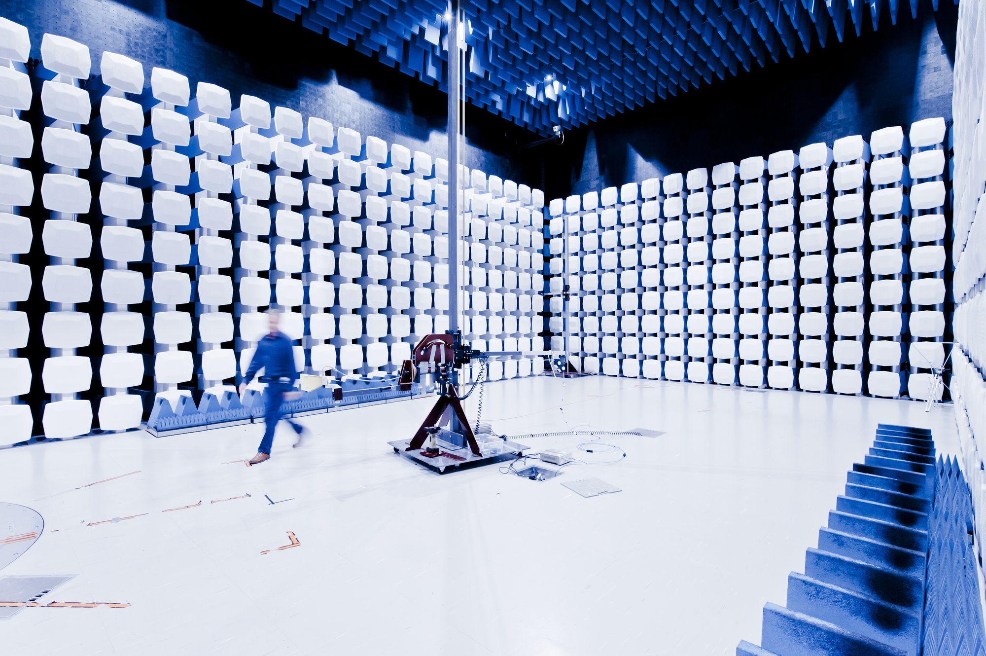 Figure 8 — A semi-anechoic EMC test chamber: hybrid ferrite-tile and foam absorber on the walls and ceiling, a conductive floor, and a turntable for the equipment under test. The whole room is a Fa…